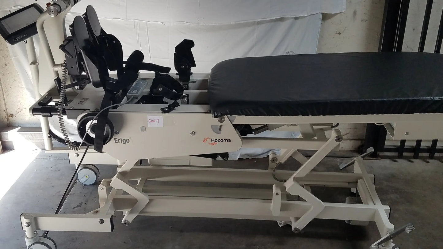 Beige hocoma ergo pro robotic tilt table with black padded surface and adjustable mechanical components for therapy