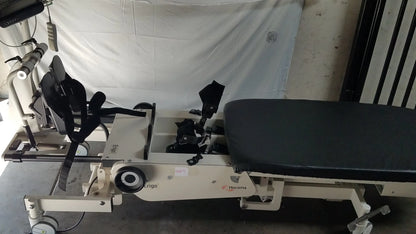 Beige hocoma erigo pro robotic tilt table with black padded seat and adjustable leg supports for verticalization therapy