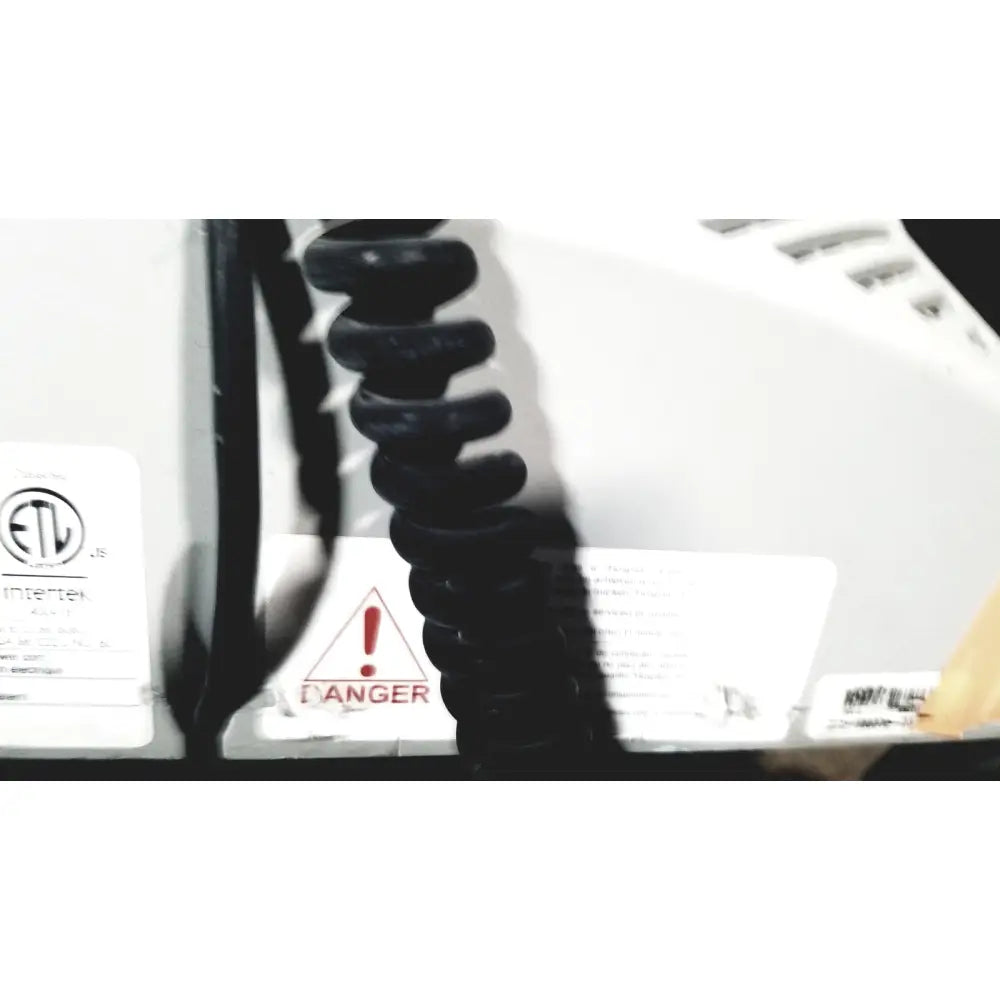Black coiled cord attached to the back of a white howard medical hi-care medical hi-care monitor and stand appliance