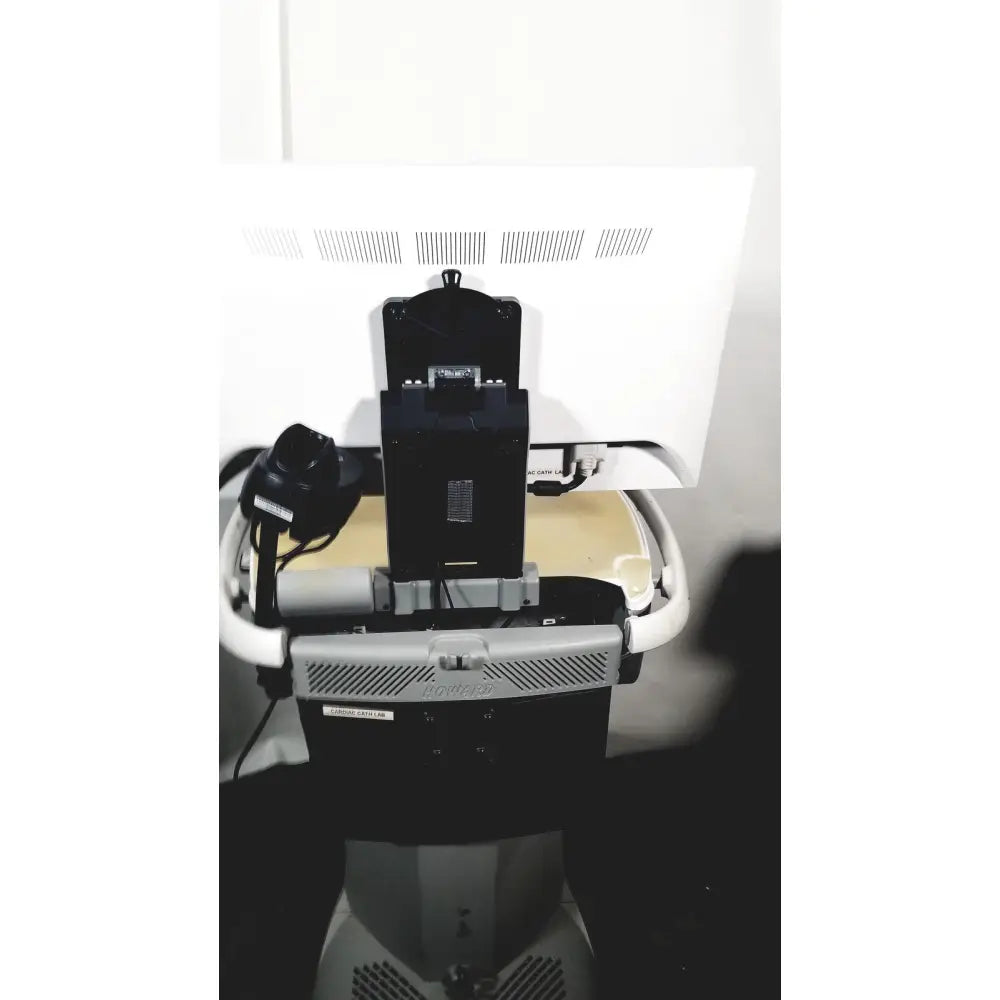 Black rectangular component of howard medical hi-care medical hi-care monitor mounted on gray and white cart back view