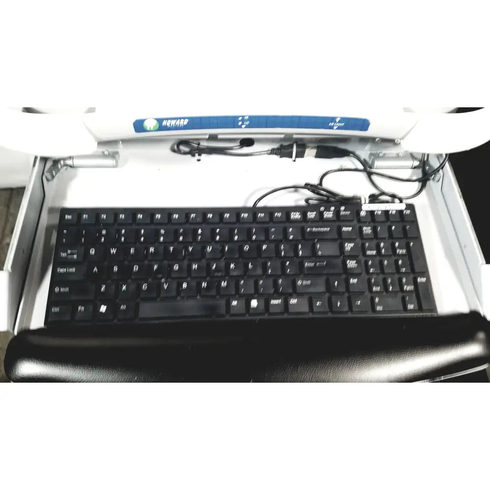 Black keyboard with white lettering and black wrist rest beneath in howard medical hi-care monitor and stand product setup