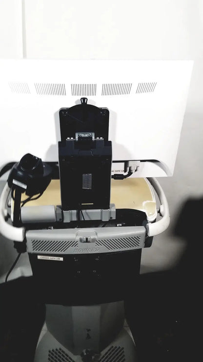 Black rectangular component of howard medical hi-care medical hi-care monitor mounted on gray and white cart back view