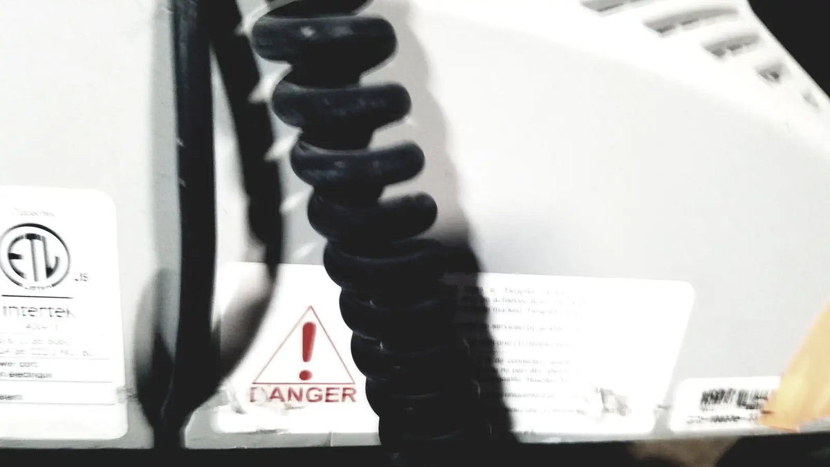 Black coiled cord attached to the back of a white howard medical hi-care medical hi-care monitor and stand appliance