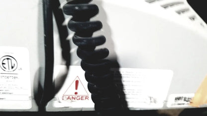 Black coiled cord attached to the back of a white howard medical hi-care medical hi-care monitor and stand appliance