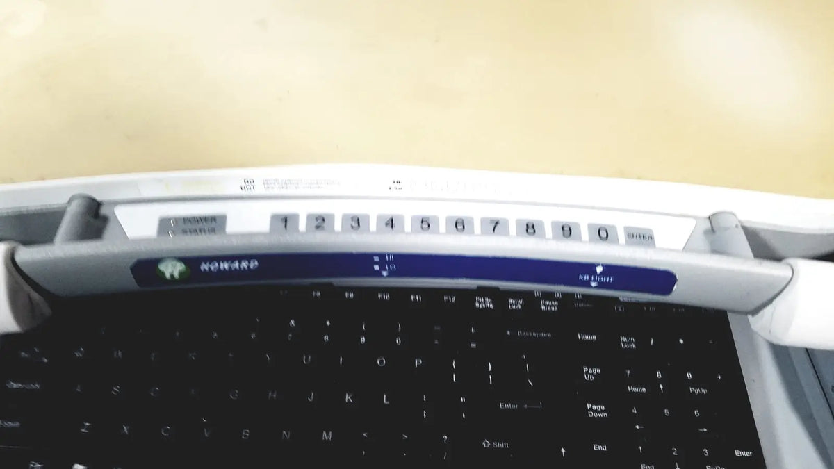 Howard Medical Hi-Care monitor and stand featuring a white and blue numeric keypad with black nowarp keys on laptop keyboard