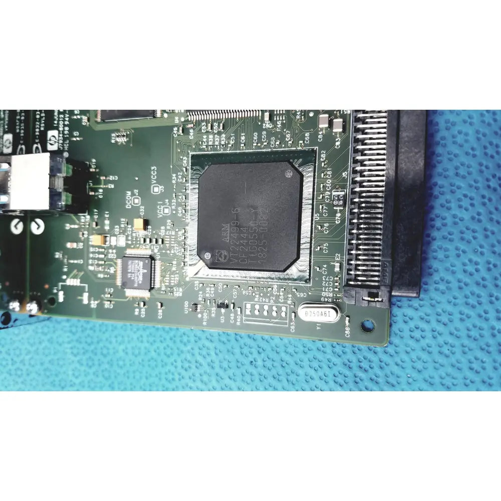 Black rectangular integrated circuit chip on green pcb of hp jetdirect 620n fast ethernet print server board
