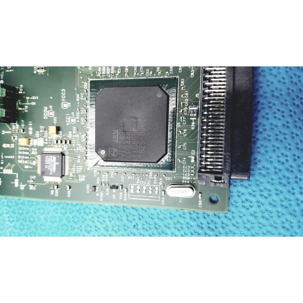 Black rectangular integrated circuit chip mounted on green pcb of hp jetdirect 620n fast ethernet print server