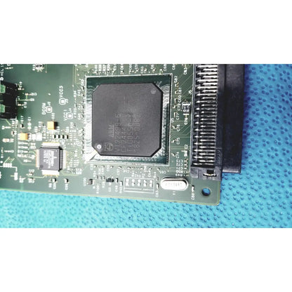 Black rectangular integrated circuit chip mounted on green pcb of hp jetdirect 620n fast ethernet print server