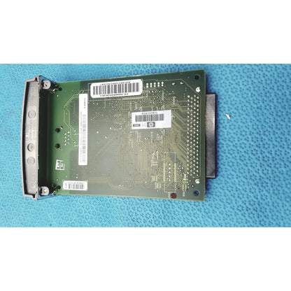 Green circuit board with silver connectors and white barcode labels of hp jetdirect 620n fast ethernet print server
