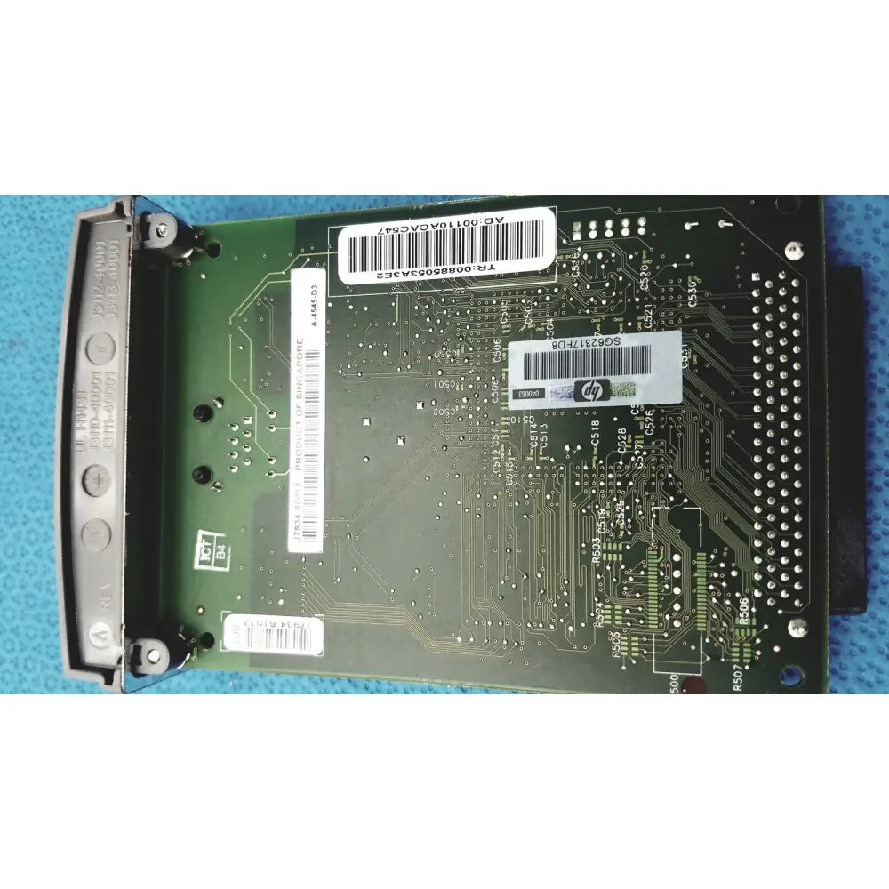 Green hp jetdirect 620n circuit board with silver solder points and white barcode labels for fast ethernet print server