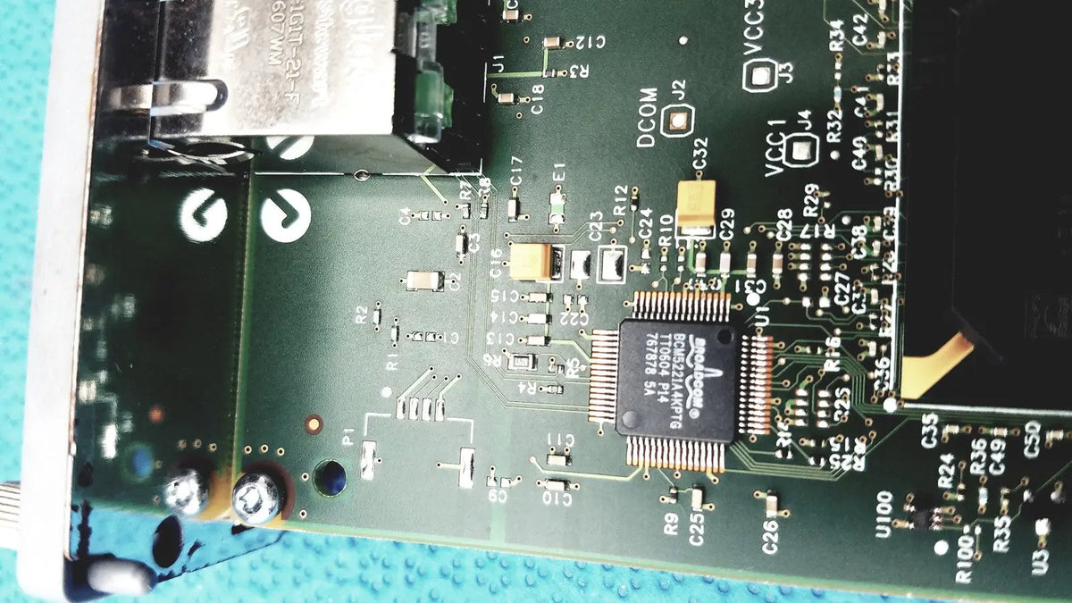 Green printed circuit board of hp jetdirect 620n fast ethernet print server with black ic chips and gold connectors