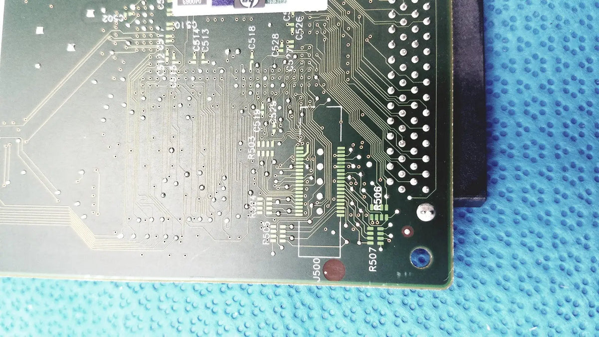 Green printed circuit board with silver traces and components of hp jetdirect 620n fast ethernet print server