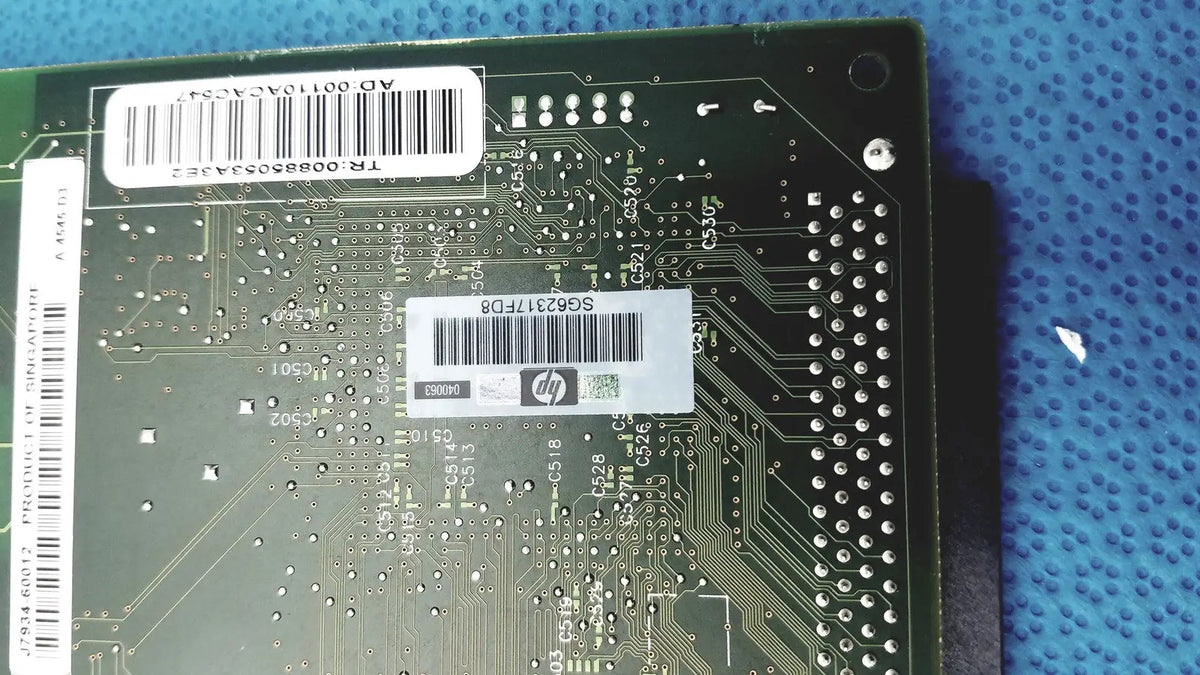 Green hp jetdirect 620n motherboard with silver circuitry and white barcode labels for fast ethernet print server use