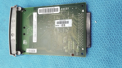 Green circuit board with silver connectors and white barcode labels of hp jetdirect 620n fast ethernet print server