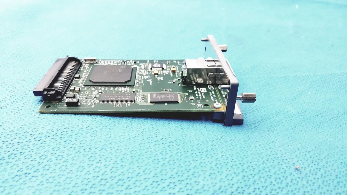 Green circuit board with black components and metallic bracket of hp jetdirect 620n fast ethernet print server