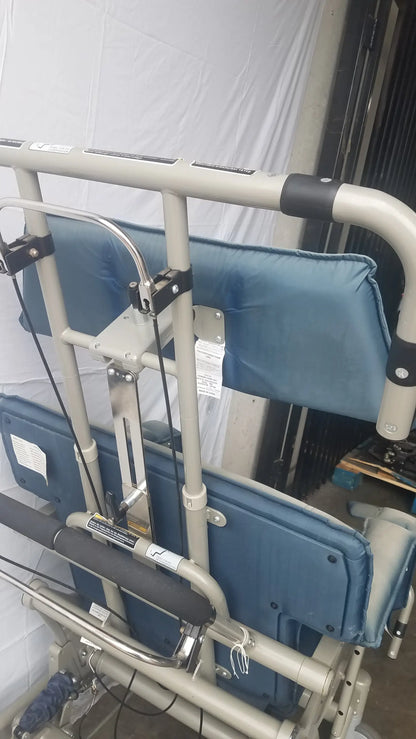 Blue padded cushioned backrest on the back side of humanCare i-400 bariatric convertible chair with silver metal frame and black handles