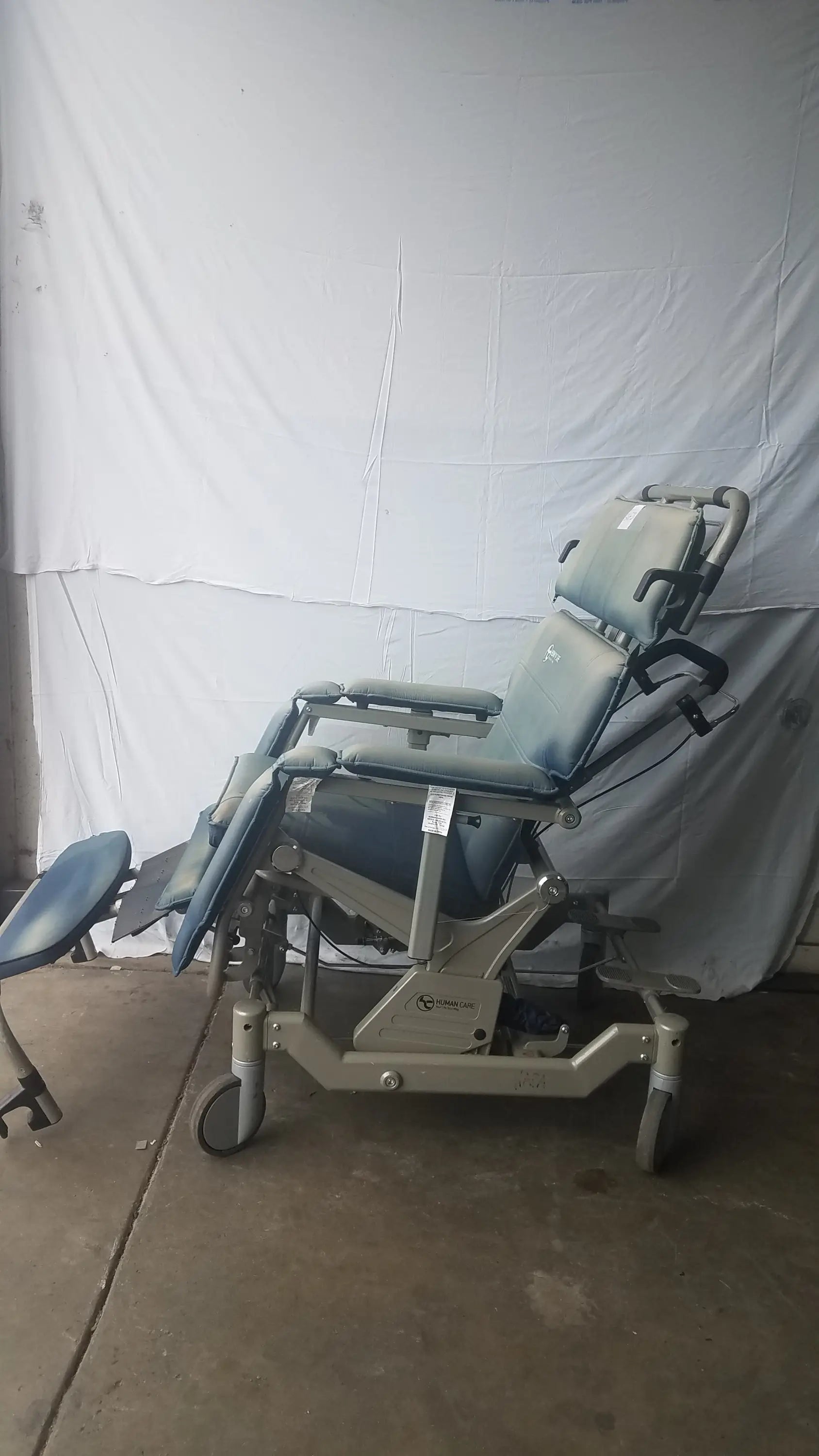 Gray adjustable humanCare I-400 bariatric convertible chair with padded upholstery and wheeled base for medical exams