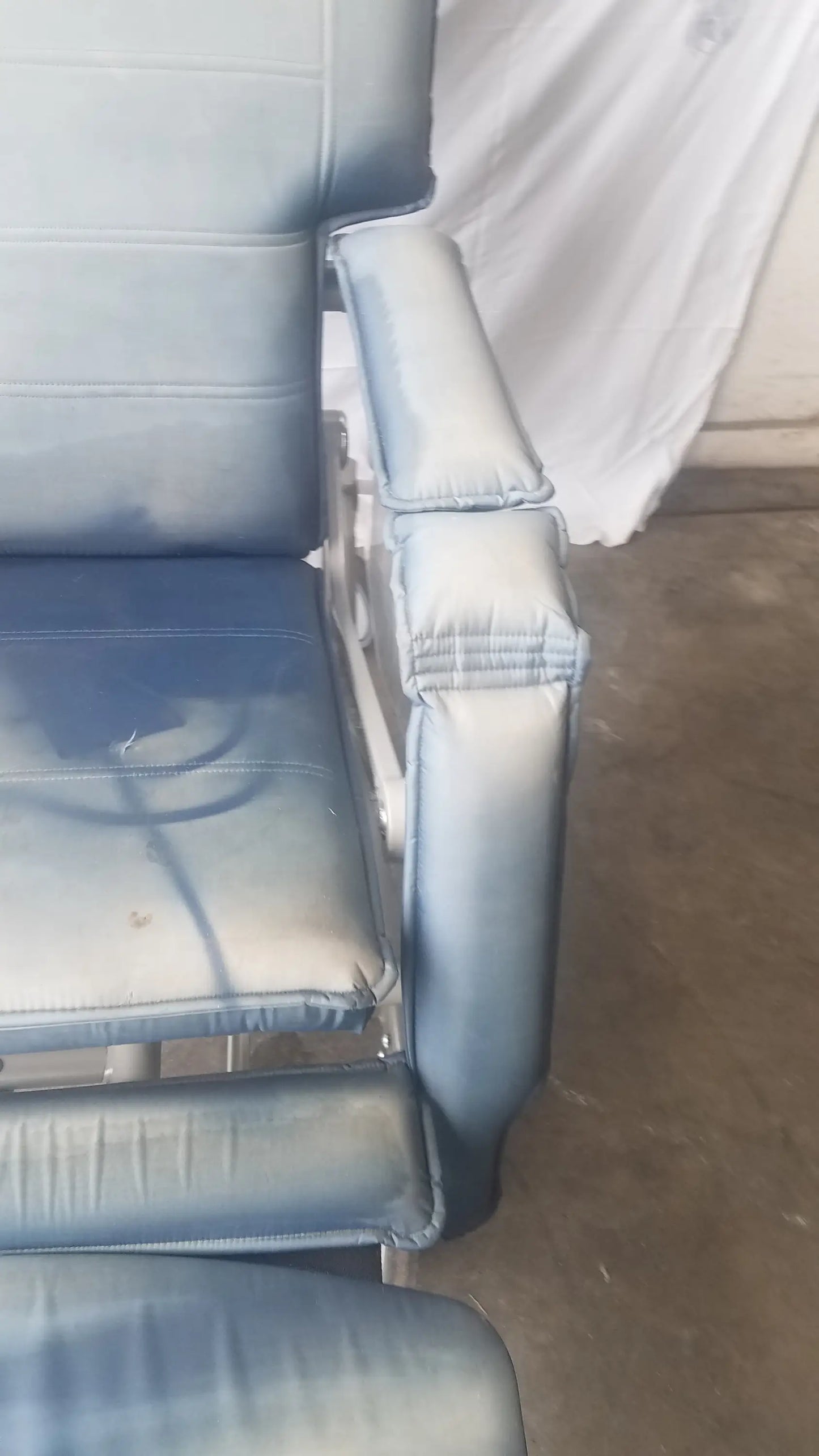 Light blue padded bariatric convertible chair with stitched upholstery and metal frame humanCare I-400 model