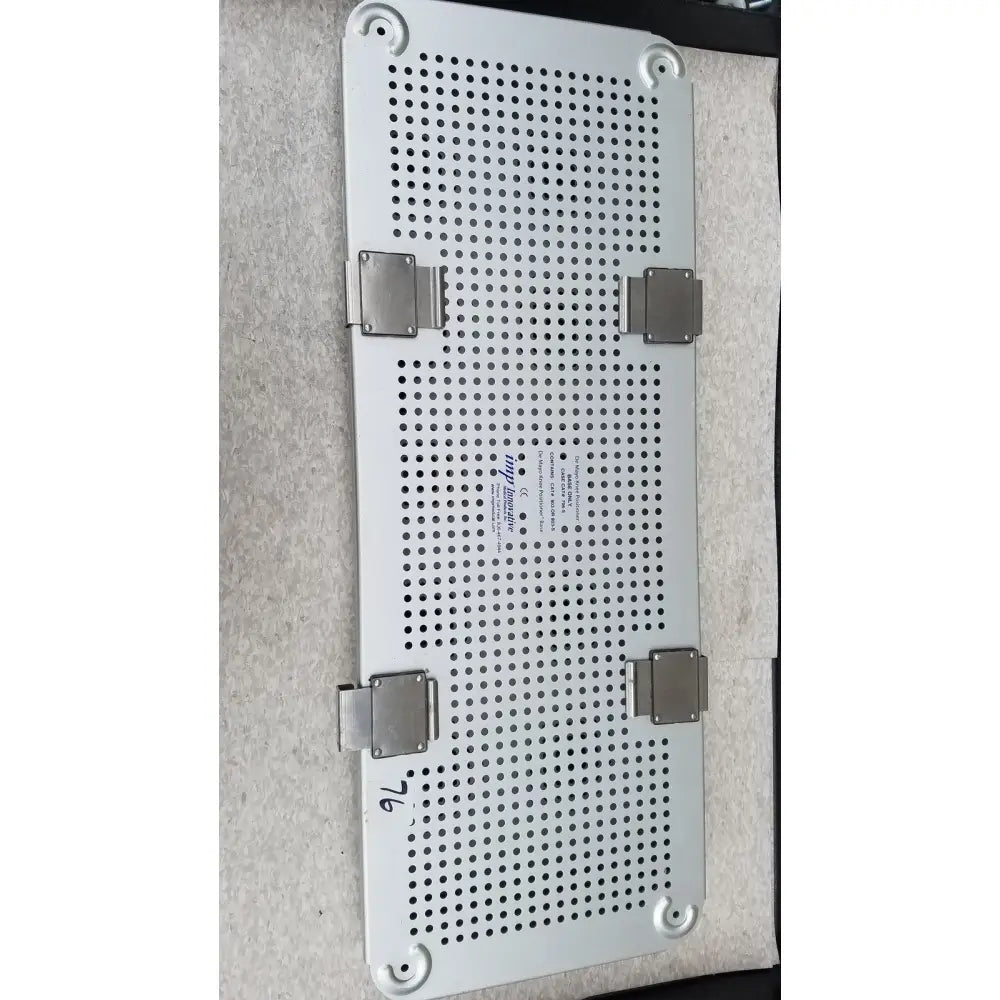 Silver perforated metal tray with four corner latches and label for imp innovative medical mayo knee positioner base tray