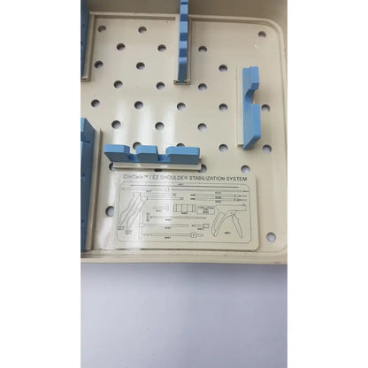 Beige plastic surgical tray with blue components and labeled diagram for Innovasive Contack ez shoulder stabilization system