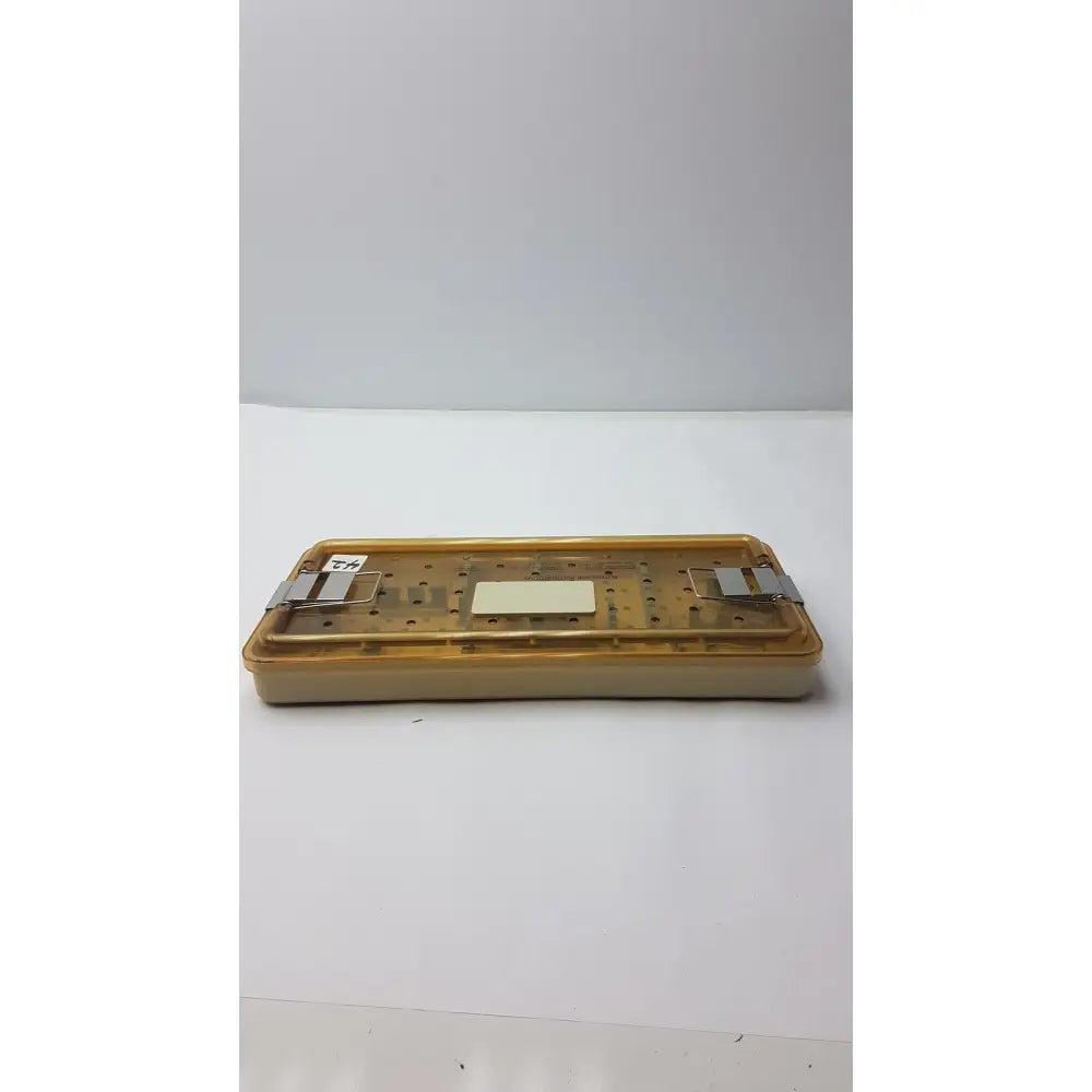 Transparent amber-colored plastic surgical tray with metal clamps for innovasive contack ez shoulder stabilization system