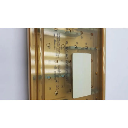 Gold-colored metal autoclave with printed instructions and white label for innovasive contack ez shoulder stabilization system empty tray