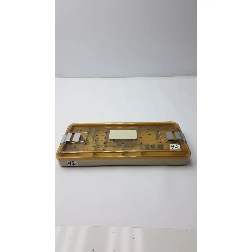 Yellowish translucent plastic surgical tray with metal clamps and white insert for innovasive contack ez shoulder stabilization system