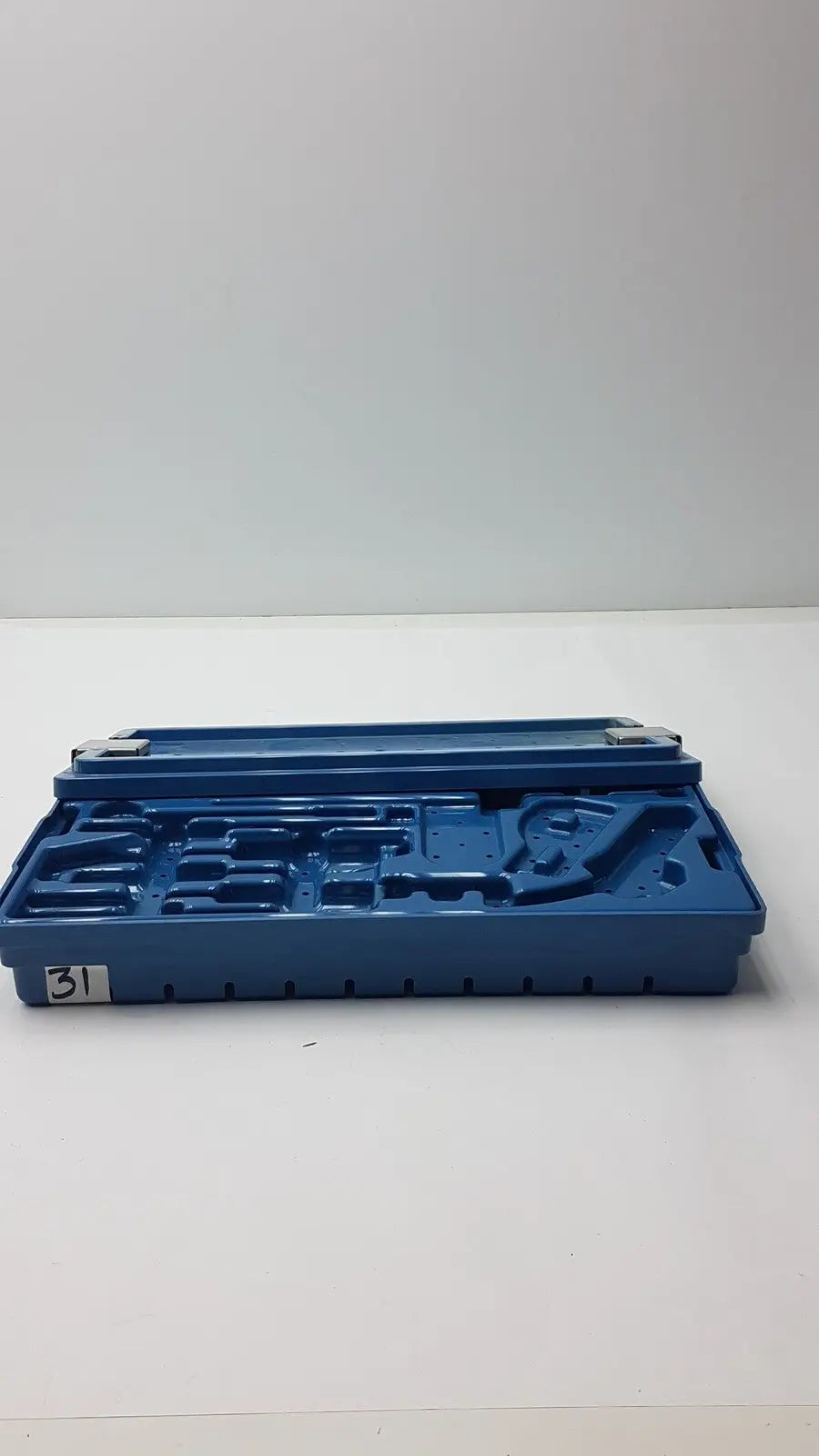 Blue plastic instrument set case container with molded compartments and numbered label for case container sterilization storage