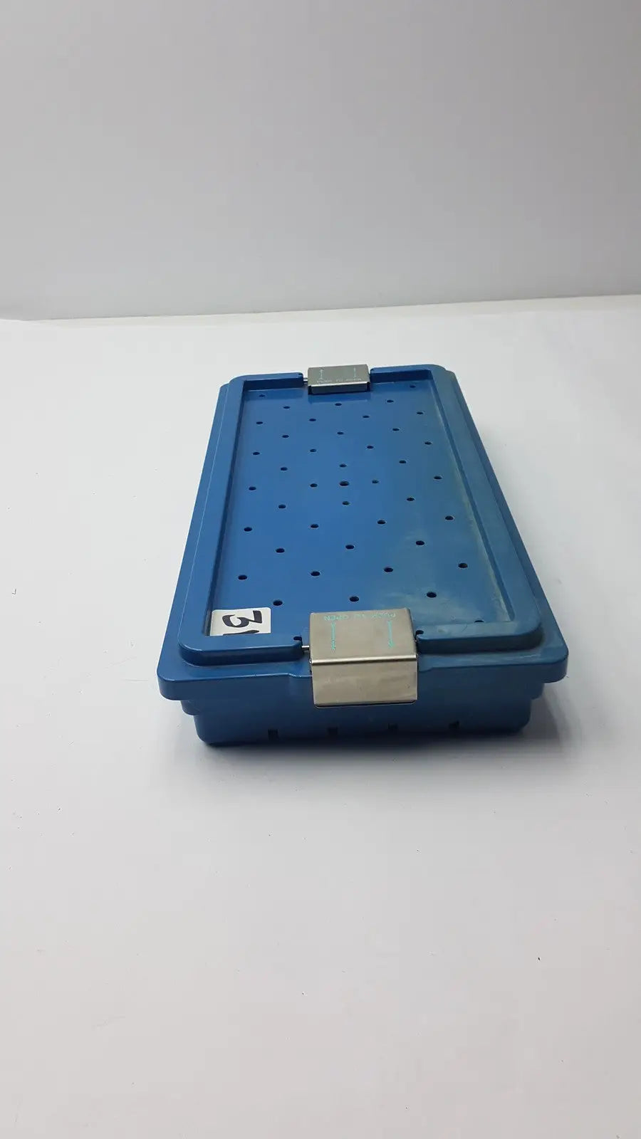 Blue plastic instrument set case container with silver metal latches and perforated design for case container sterilization