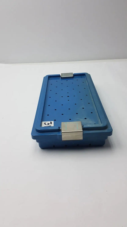 Blue plastic instrument set case container with silver metal latches and perforated design for case container sterilization