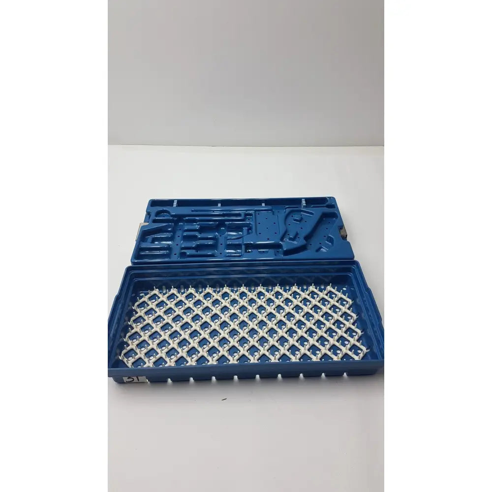 Blue plastic instrument set case with white grid-patterned interior for sterilization and storage container