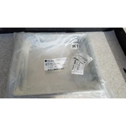 White sklar plastic instrument tray sealed in clear packaging labeled for reuse medical sterilization trays use
