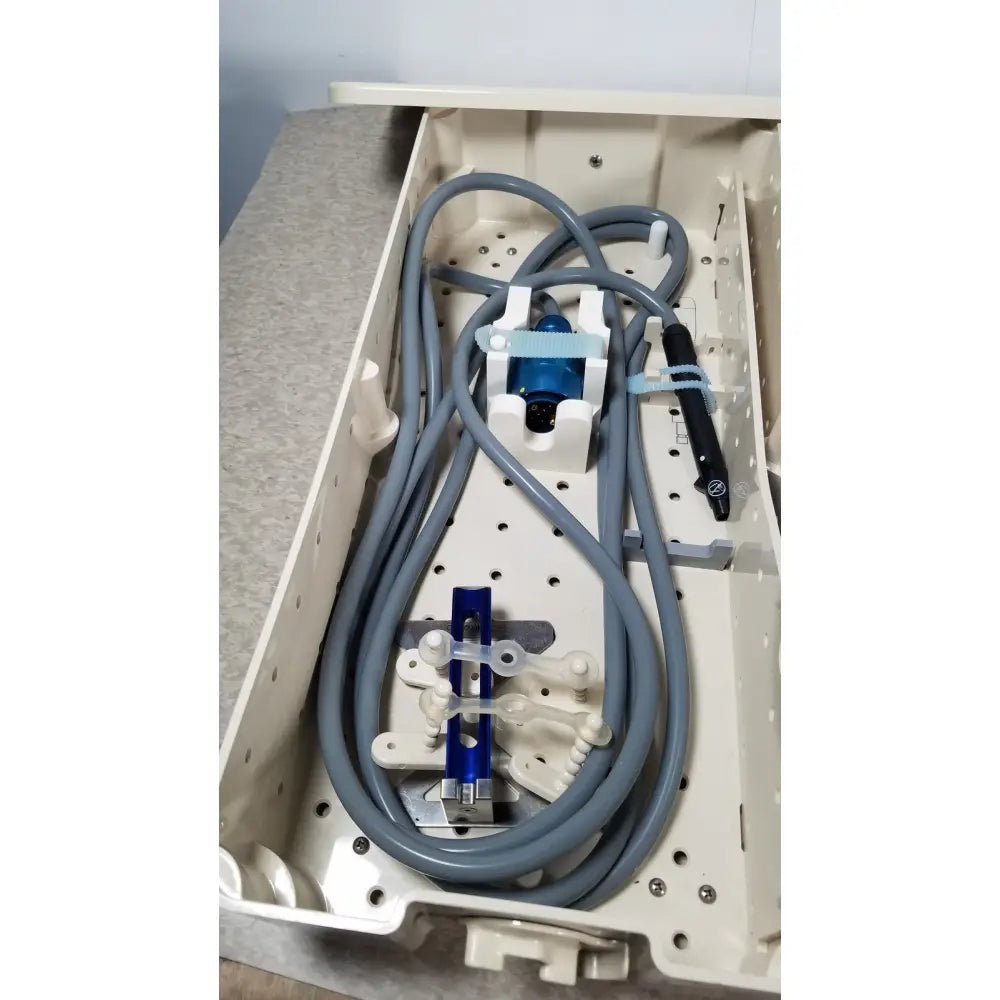 Gray coiled tubing with blue and black medical devices secured in a beige tray for integra cusa excel clarity handpiece ultrasonic system