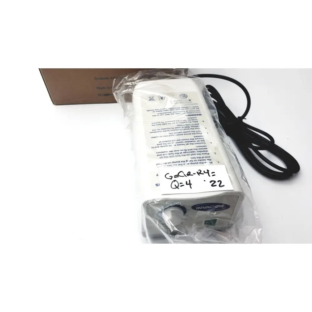 White plastic invacare alternating pressure pump cg9701 power adapter with black cord and label for air mattresses
