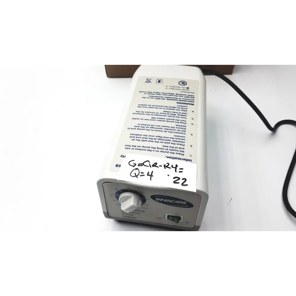 White plastic invacare alternating pressure pump cg9701 with black power cord and control dial for air mattresses