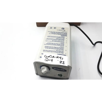 White plastic invacare alternating pressure pump cg9701 with black power cord and control dial for air mattresses