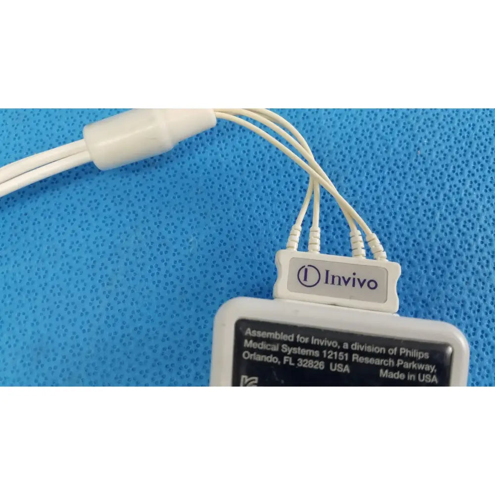 White plastic wireless ecg module with multiple thin cables and invivo label by philips for medical use