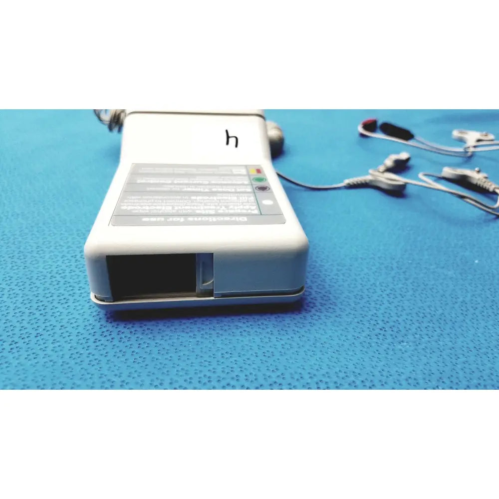White rectangular phoresor ii pm700 iontophoretic drug delivery system with gray label black screen and attached electrodes