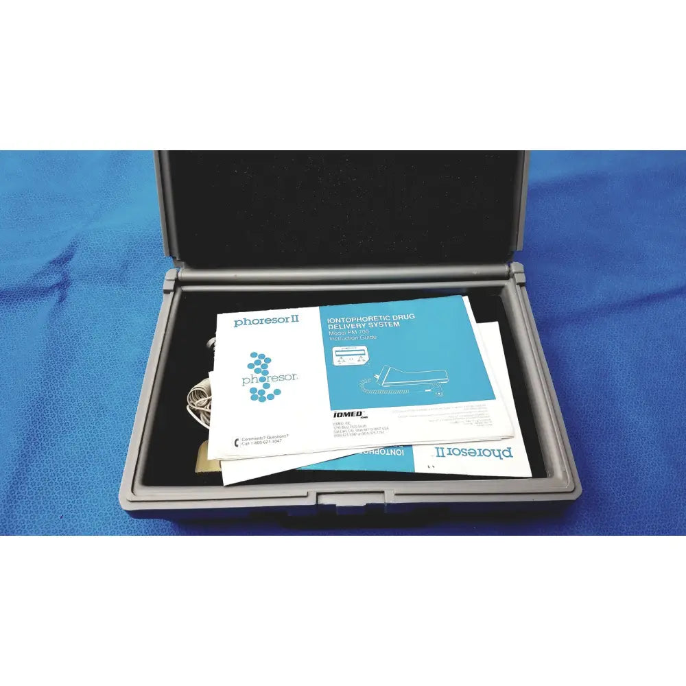 Gray hard-shell carrying case with phoresor ii pm700 iontophoretic drug delivery system manuals and cables inside