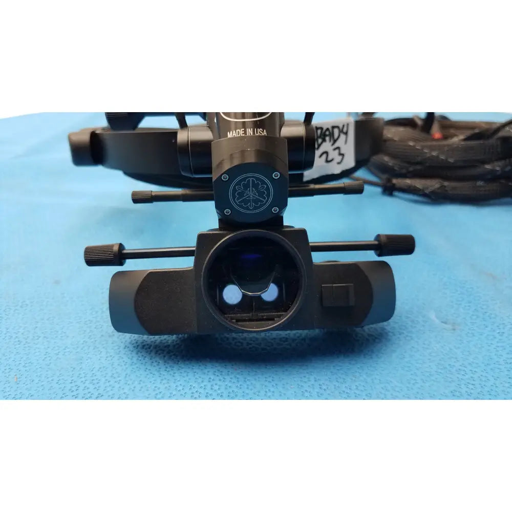 Black metal iris medical laser indirect ophthalmoscope with circular lens housing and adjustable focus knobs for ophthalmic use
