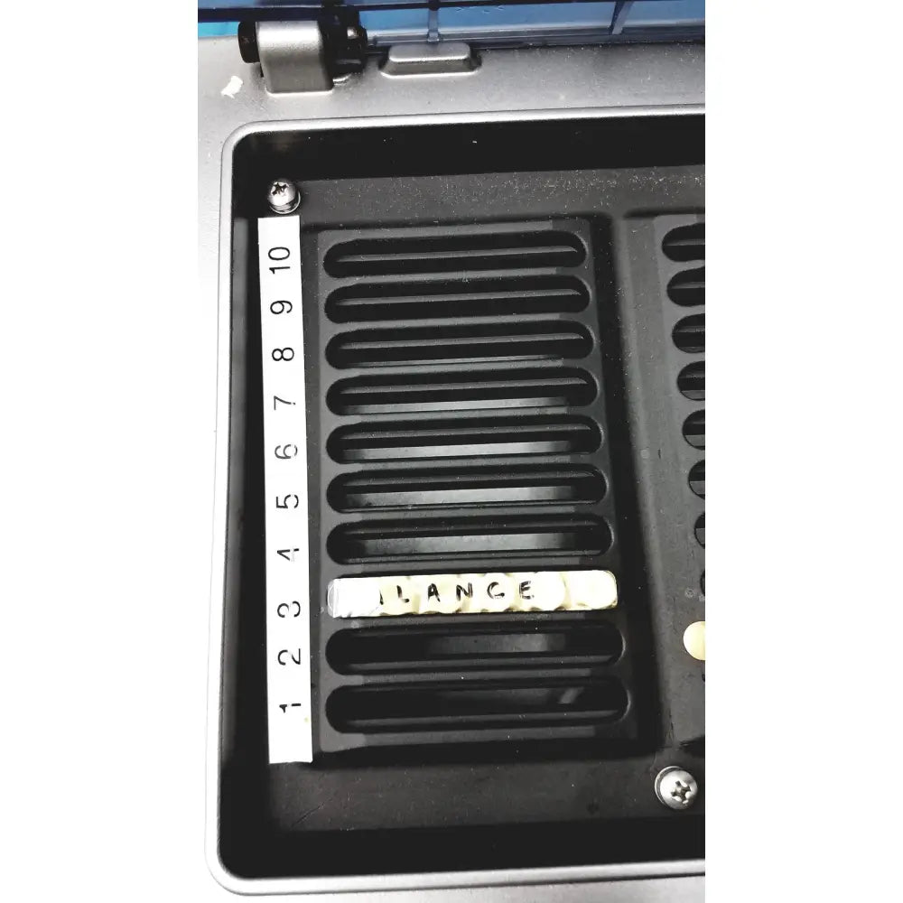 White letter tiles spelling lance in a black tray with numbered markings for diagnostic ivd ortho workstation use