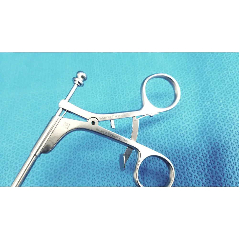 Silver stainless steel laparoscopiic clamp with rounded handle and engraved markings for surgical use