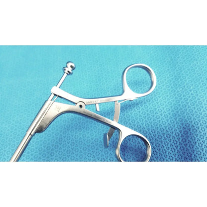 Silver stainless steel laparoscopiic clamp with rounded handle and engraved markings for surgical use