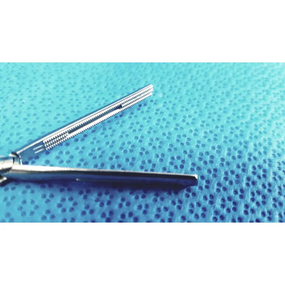Jarit 610-140 roto-lok stainless steel clamp with serrated jaws silver surgical steel clamp on blue textured surface