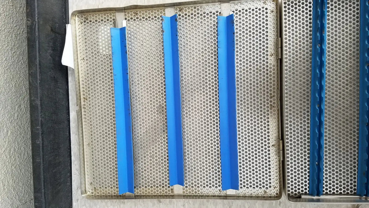 Blue plastic strips affixed to a perforated jarit stainless steel 37988a sterilization case grid panel