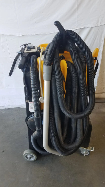 Black and yellow Kaivac wet dry vacuum cleaning system with multiple hoses coiled around its industrial body