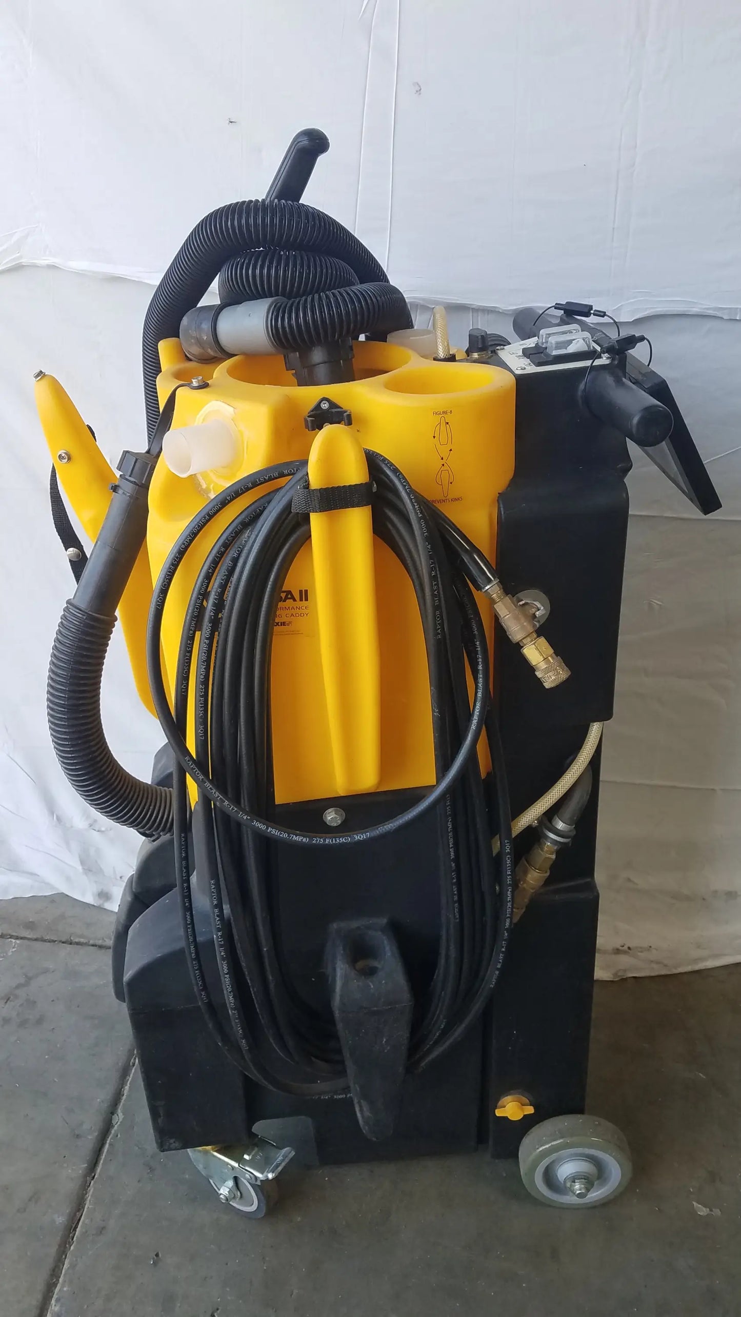 Yellow and black Kaivac wet dry vacuum cleaning system with coiled hoses and wheels for industrial floor cleaning