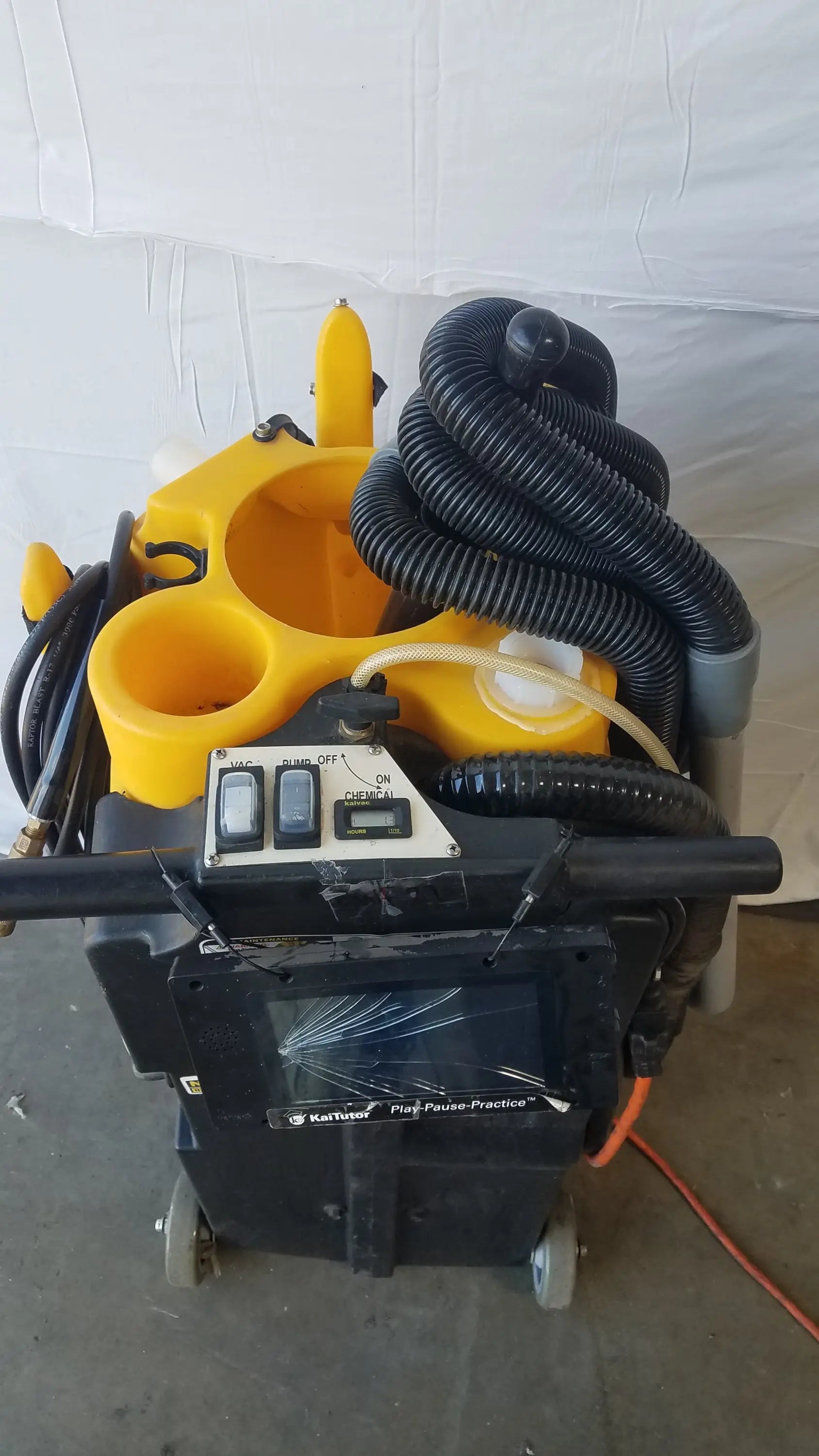 Yellow and black Kaivac wet dry vacuum cleaning system with coiled hoses and control panel for industrial floor cleaning