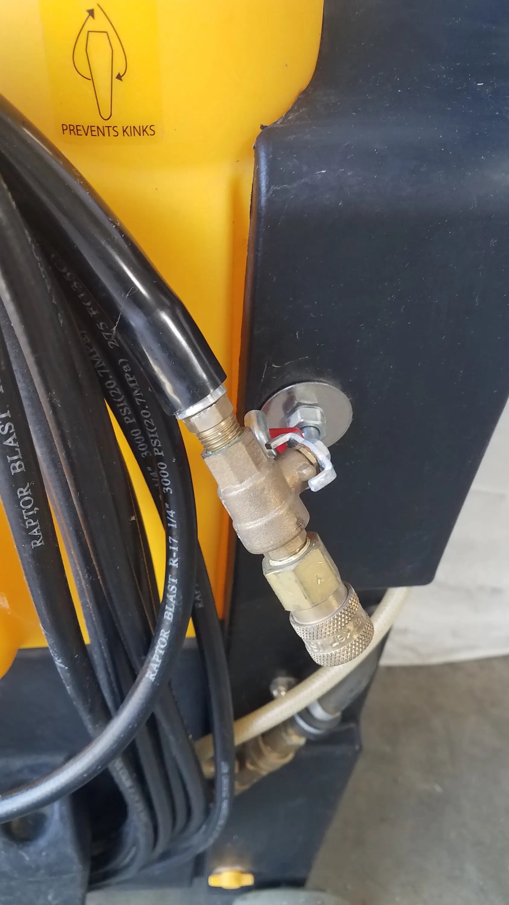 Yellow and black Kaivac wet dry vacuum cleaning system with coiled black hoses connected to brass fittings