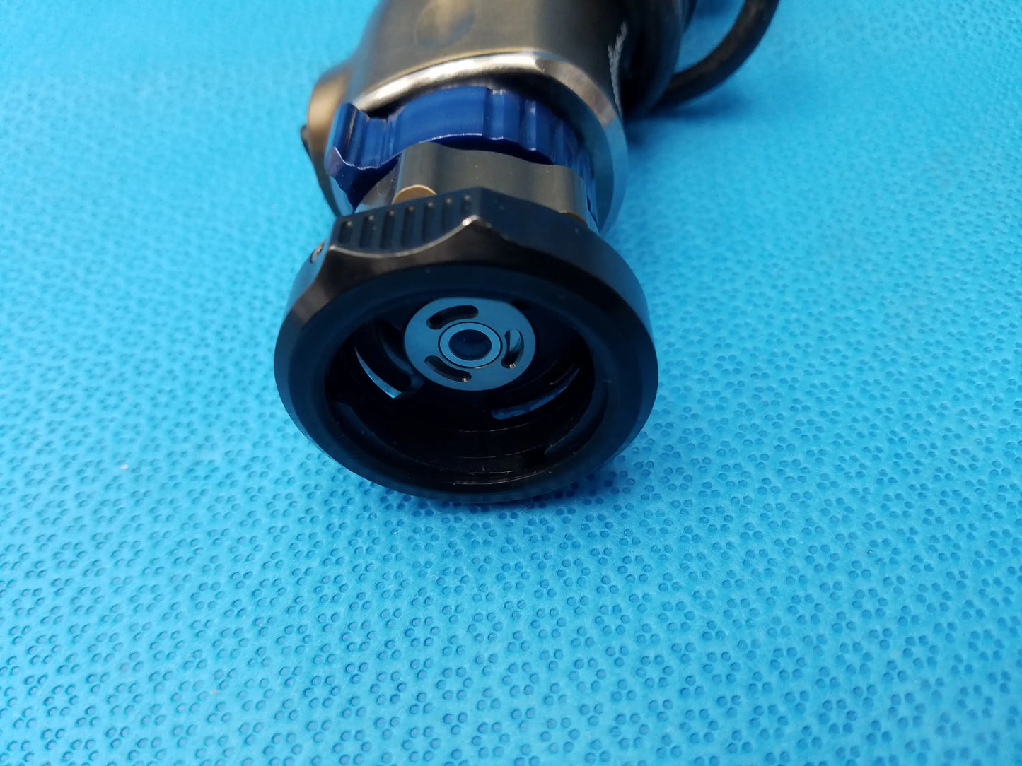 Black and blue handheld spray nozzle with textured grip and metallic components for karl storz precision imaging camera head